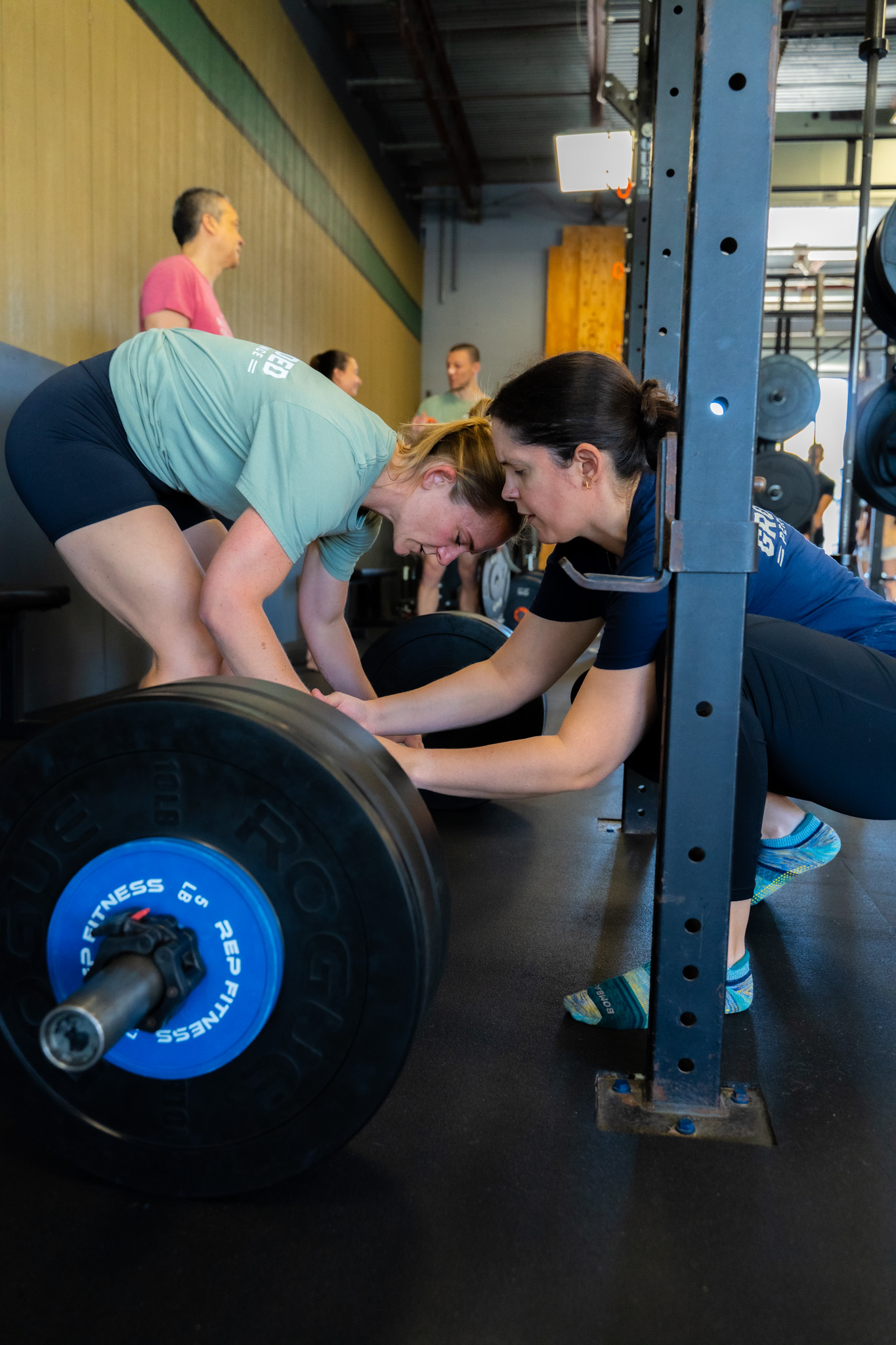 Coach guiding a member through a deadlift setup during small group training at Grounded Performance ATX